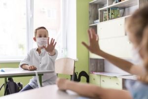 kids-waving-classroom-while-keeping-social-distance