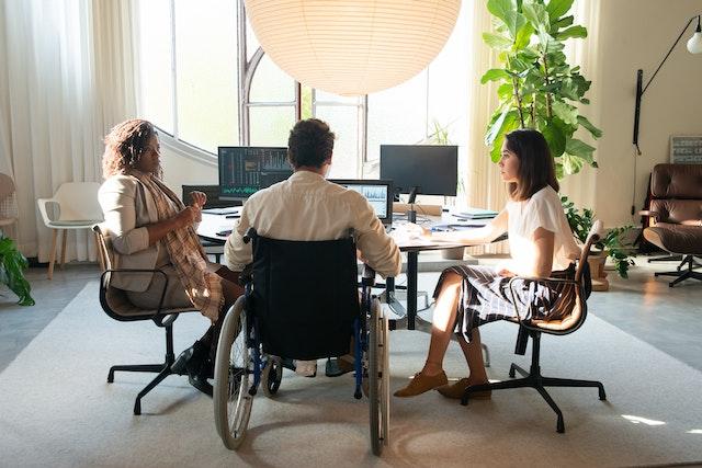 a-man-with-wheelchair-and-two-woman-doing-meeting-in-a-company