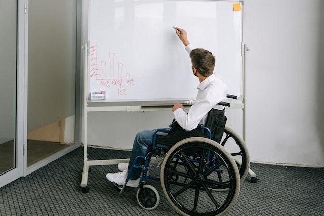 a-man-with-wheelchair-writing-on-board